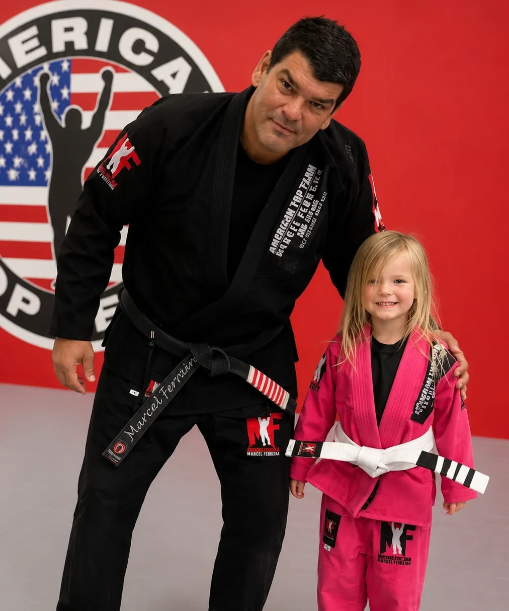 Coach Marcel Ferreira with a young student in a pink gi at ATT Winter Garden