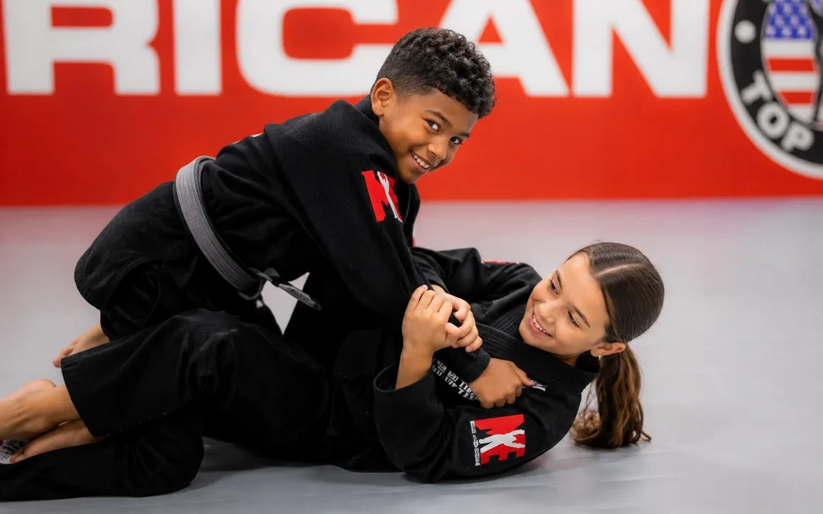 Two older kids smiling while training Brazilian Jiu-Jitsu at ATT Winter Garden